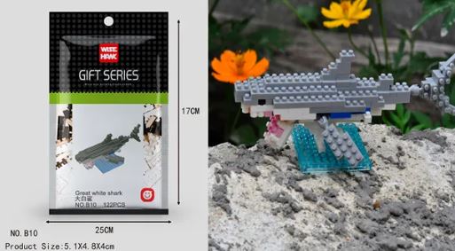 The Wisehawk Mini Nano Micro Diamond Animal Building Blocks packaging displays dimensions for a shark model. To the right, a finished gray and white shark sits on a blue base with greenery and orange flowers, set outdoors.