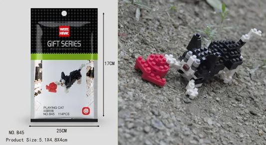A Wise Hawk Gift Series packaging bag holds a pixelated toy cat and fish model made from Mini Nano Micro Diamond Animal Building Blocks. The black and white cat interacts with a red fish on grass beside the 17x25 cm bag.