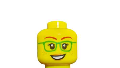 Close-up of a LEGO 6271746 Minifigure Head (UB1034) featuring vibrant green glasses, freckles, and two playful expressions: one with a warm smile and the other subtly different.