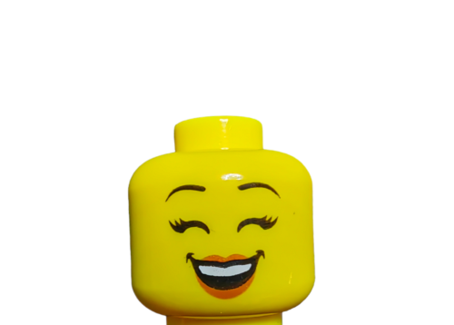 Close-up of the LEGO 6306822 Minifigure Head, a yellow dual-sided female head with black eyebrows, showing a cheerful expression with closed eyes and an open-mouth smile with red lipstick on a white background.