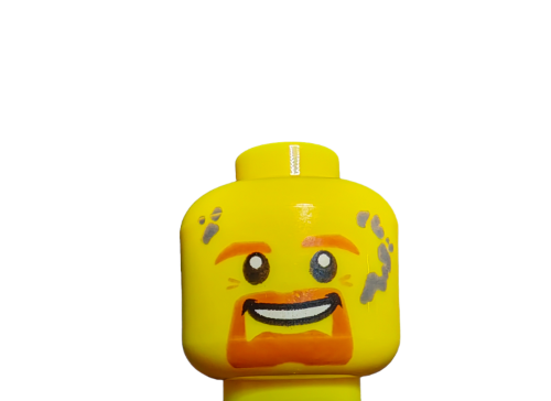 Close-up of LEGO 6132559 Minifigure Head, featuring an open-mouthed smile, orange eyebrows and beard resembling Ginger Beard Oil, with gray smudges on the forehead and cheeks, set against a plain white background.
