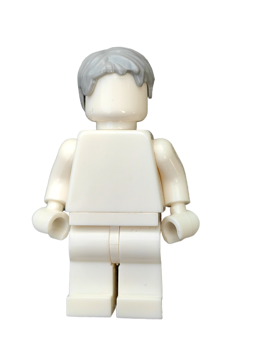 A white Lego minifigure with a blank face wears the LEGO 6075237 Wig, Grey Hair Short Messy Look - UB1294, against a white background. While the figure has no distinct features or clothing, the wig adds character.