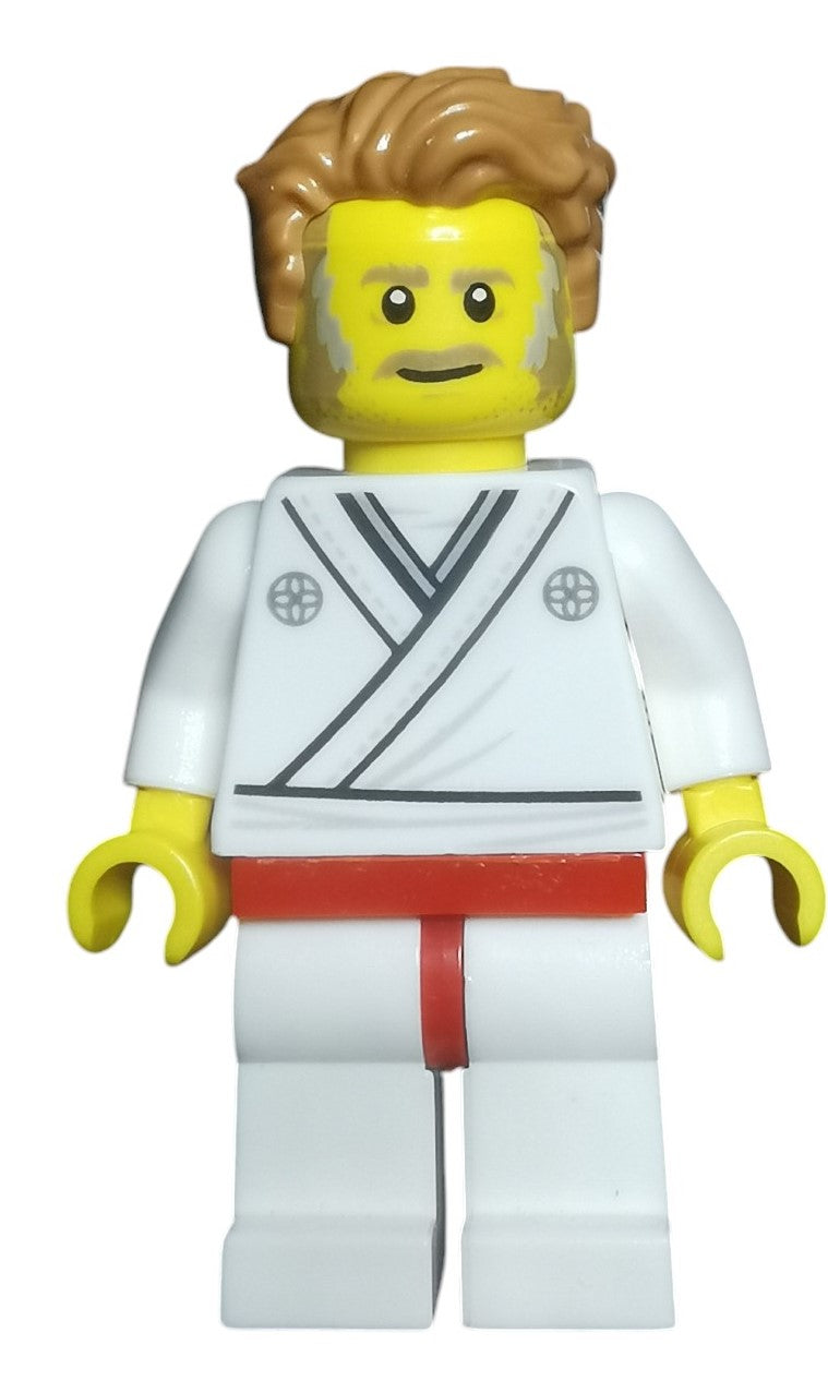 The Martial Arts Minifigure Gift for Grading showcases a yellow-skinned figure with styled brown hair and facial hair, dressed in a white gi with black and red belts. It is set against a plain white background.