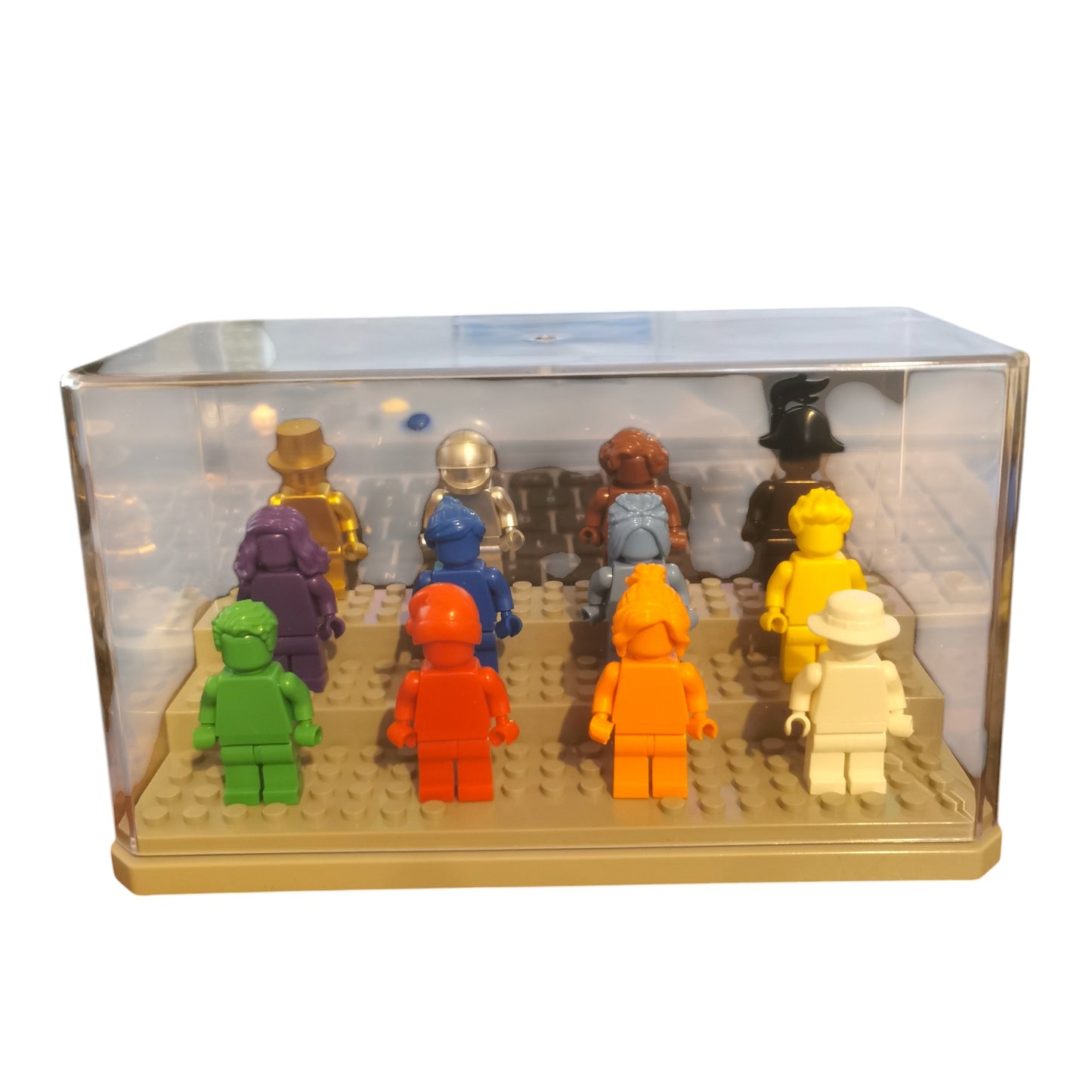 A display case features 12 vibrant Color Minifigures arranged on a baseplate in eye-catching hues of green, red, orange, white, purple, blue, silver, brown, and yellow. Some wear hats or helmets for added charm.
