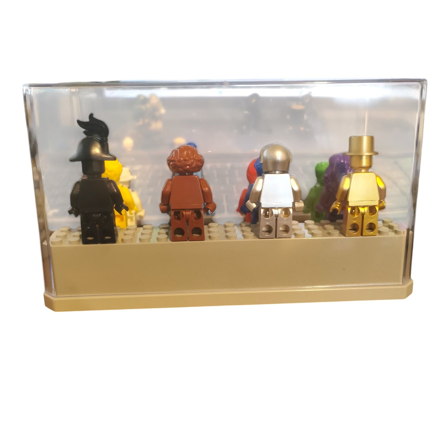The Vibrant Colour Minifigures, viewed from the back, are showcased in a clear display case. These 12 eye-catching figures feature diverse accessories like helmets and hats, all neatly arranged on a beige baseplate.