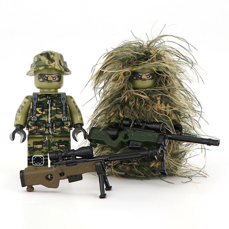 The Custom LEGO Minifigure Sniper set includes two camouflaged figures. One in a green outfit with a hat, and the other in a ghillie suit. Both come equipped with detailed toy rifles.