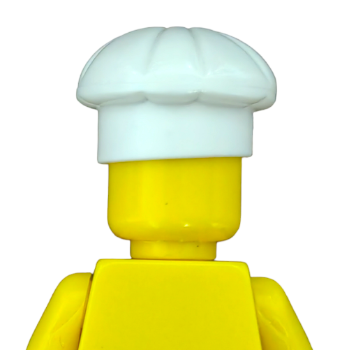 A yellow LEGO minifigure with a white chefs hat from the LEGO 6174310 set stands against a plain background, showcasing the Hat, Chef or Bakers Hat - UB1376 accessory on its head and shoulders.