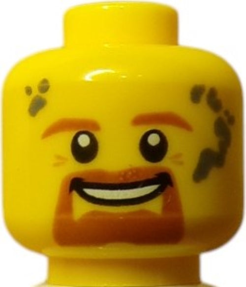 A close-up of the LEGO 6132559 Minifigure Head reveals round eyes, a wide grin, ginger beard, eyebrows, and subtle gray smudges on both sides. This playful expression adds character to Brickstars collection.